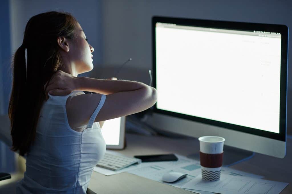 Businesswoman kneading stiff neck